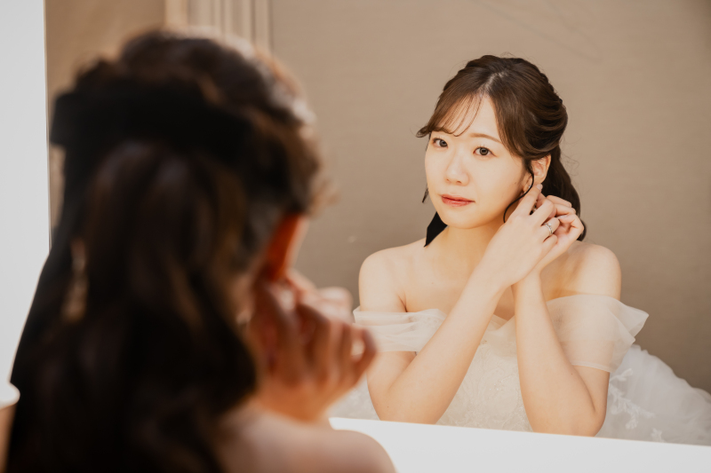 耳元に手を添え整える途中