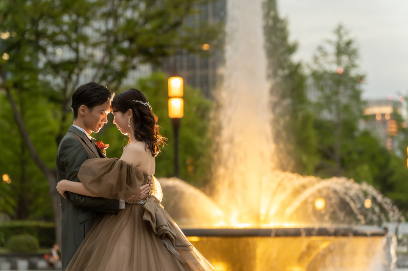 噴水の光を背にドレスごと抱きしめる二人