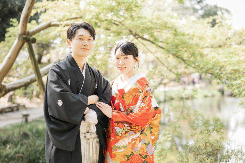 緑の木立の中に並ぶ色打掛と紋付袴
