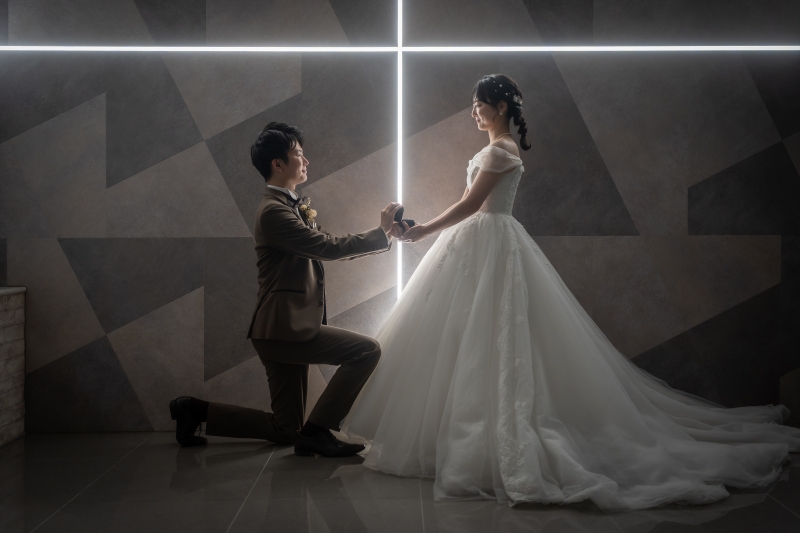 クロス照明前で片膝をつく新郎様と新婦様