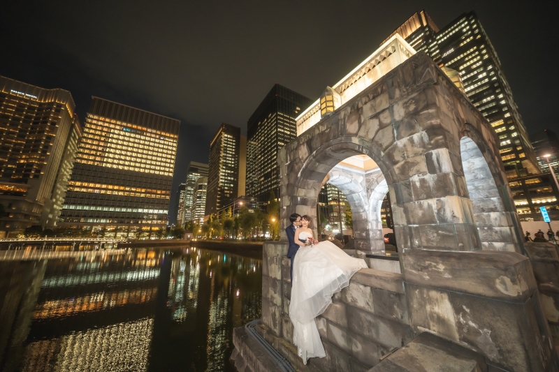 夜の石橋アーチに向かってドレスを翻すポーズ