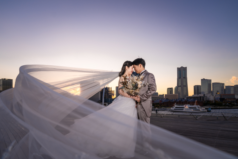 ベールをなびかせて寄り添う夕暮れの二人