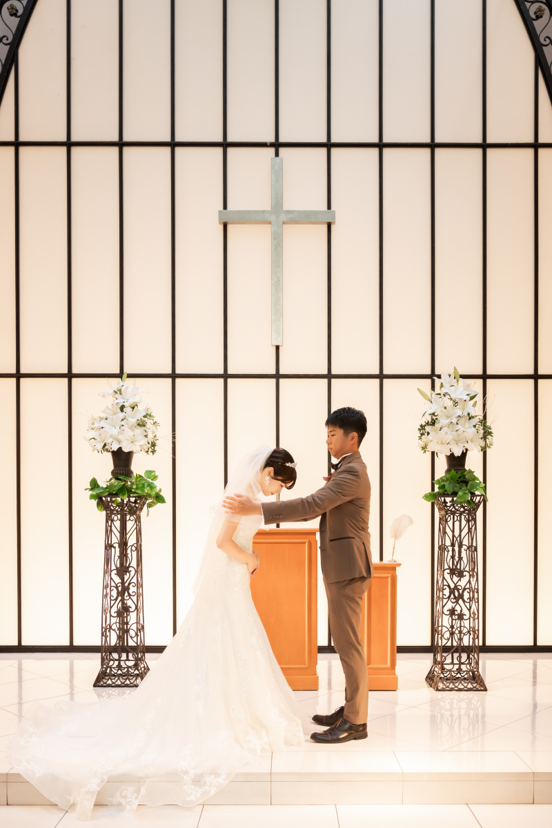 祭壇前で向かい合う新郎新婦様