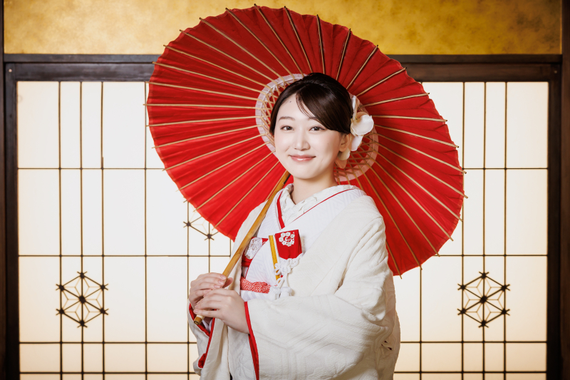 赤い唐傘の下の白い微笑み