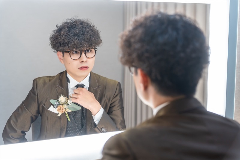 襟元を整える指先の真剣さ