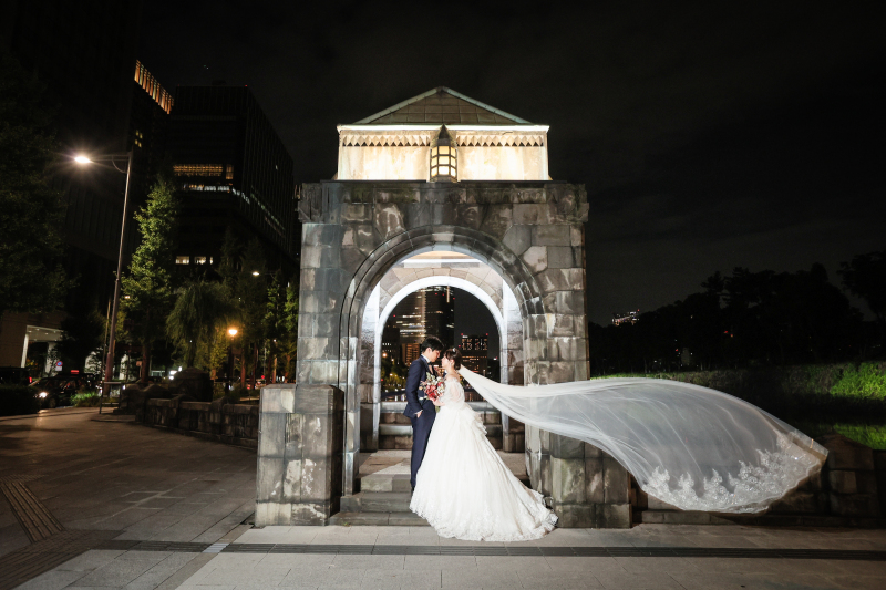 門の前でベールが揺れる花嫁