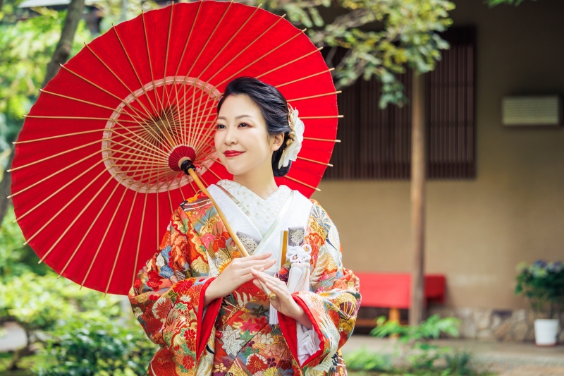 赤い番傘を差して微笑む色打掛の横顔