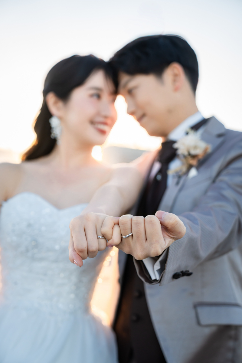  額を寄せ合って指輪を差し出す二人