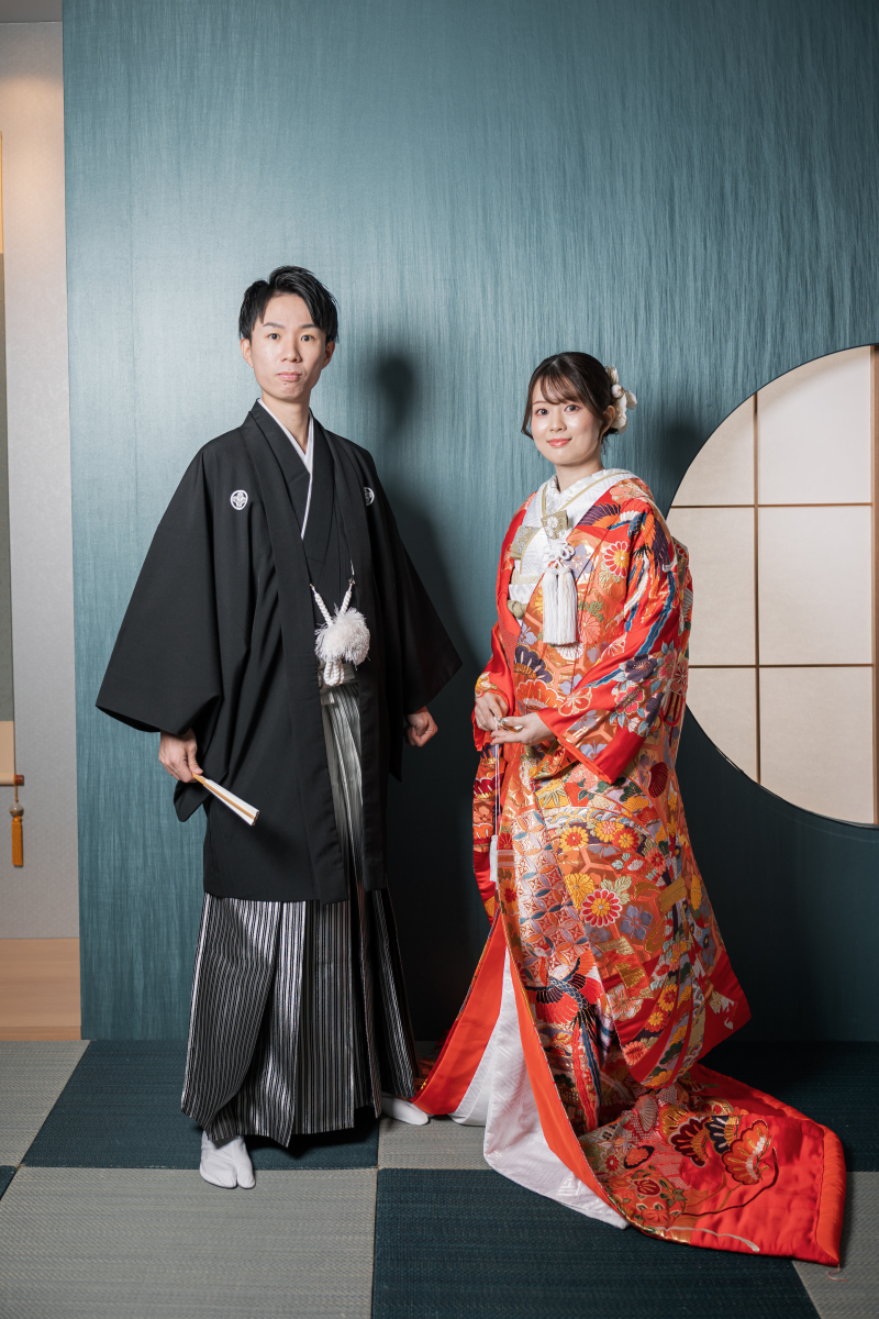 黒紋付と赤の色打掛で正面を向く新郎新婦様