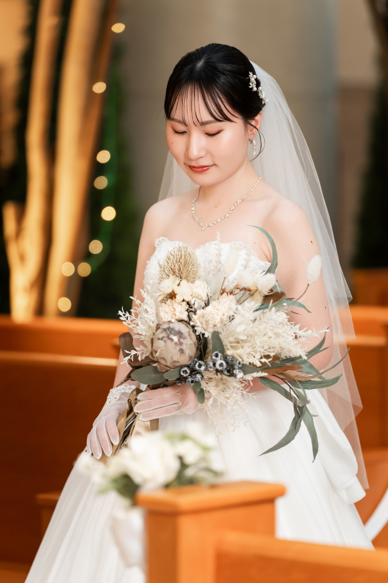 ブーケに視線を落とすベール姿の花嫁