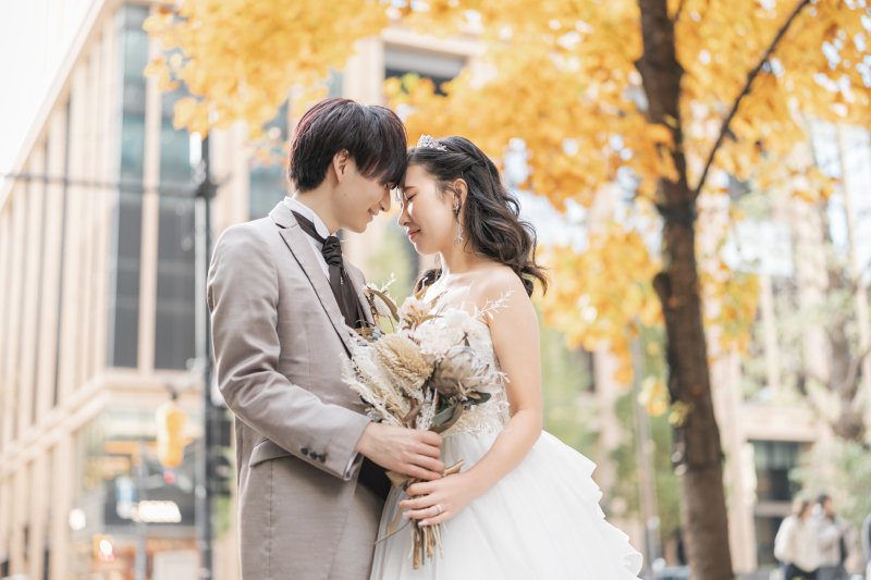 黄葉の下で額を寄せ合う穏やかな表情