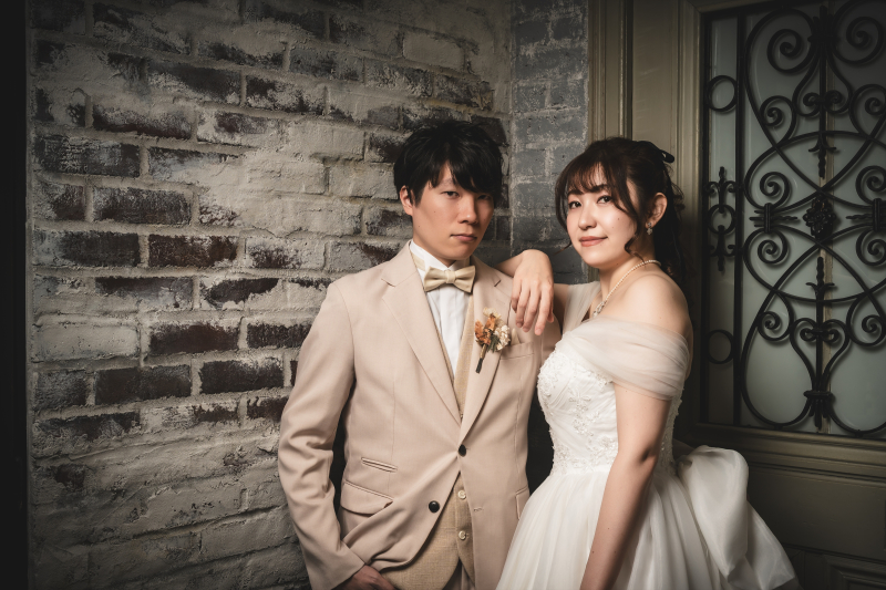 肩に手を置きながら前を向くタキシード姿