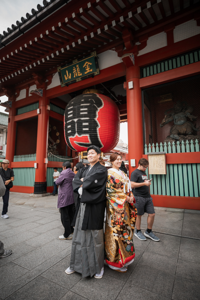 路地に明るく映える色打掛と黒紋付