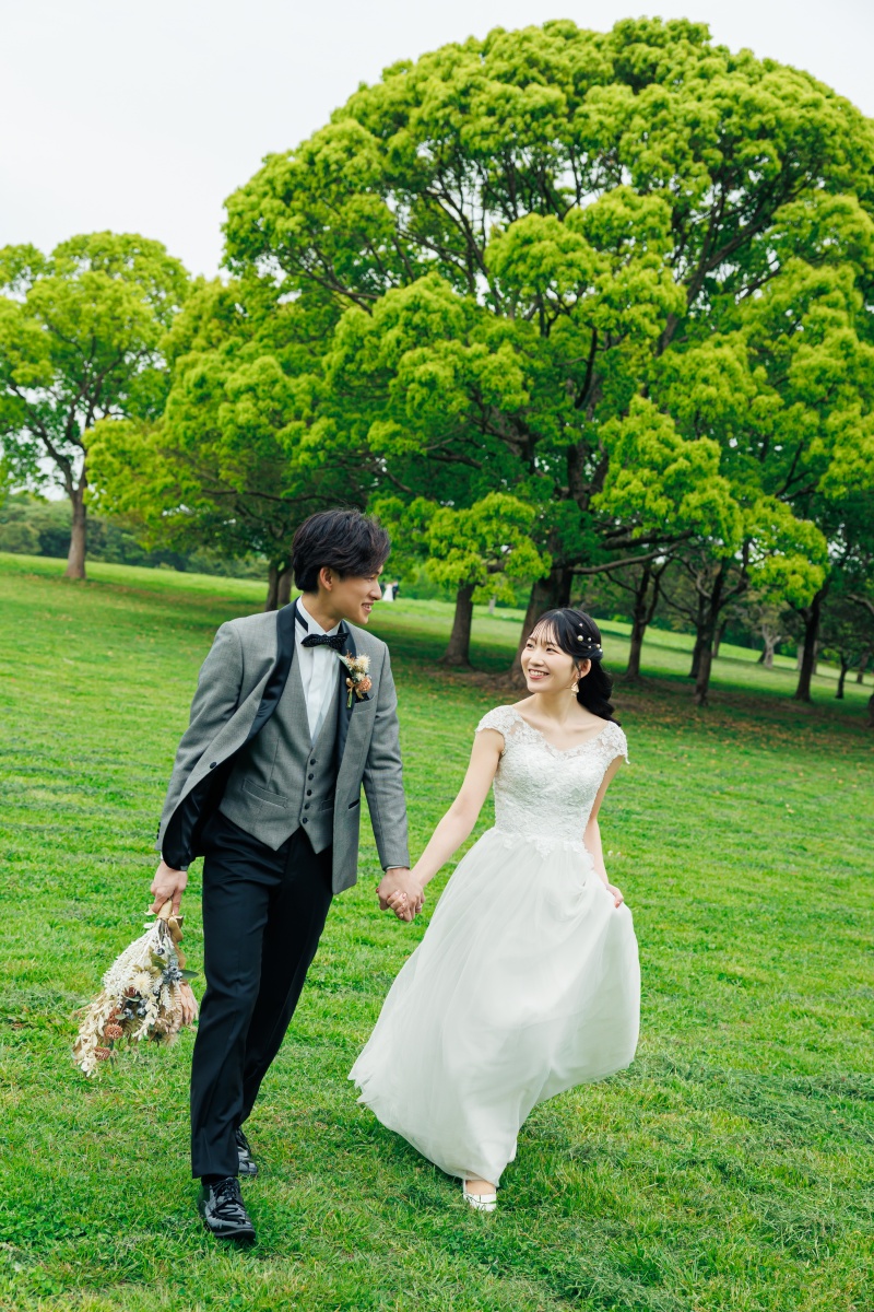 芝生を手をつないで歩くドレスの軽やかさ