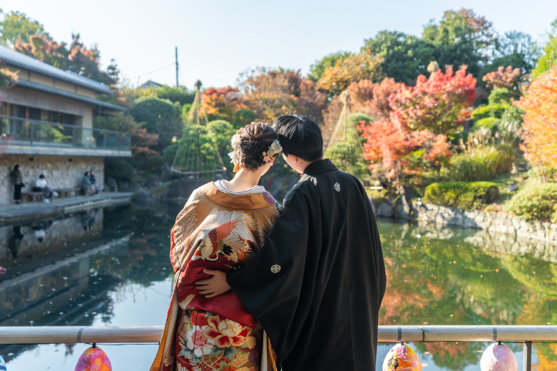 池を前に肩を寄せ合う後ろ姿の温もり