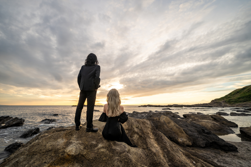 立つ新郎様・岩に座る新婦様の後ろ姿