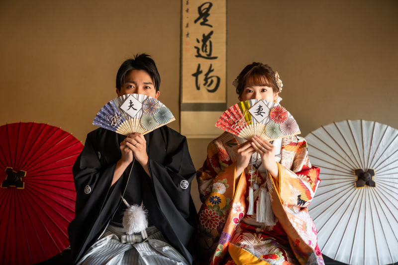 扇で顔を隠す茶目っ気あふれる表情