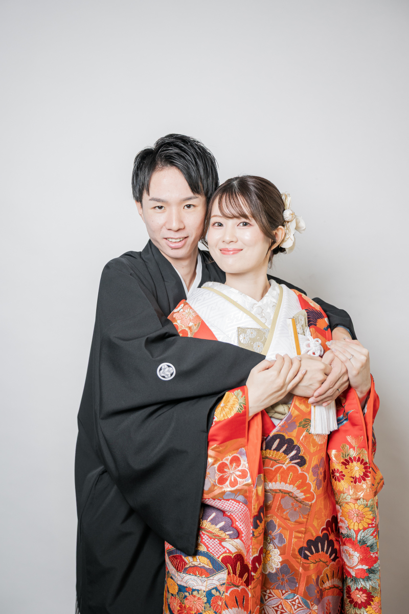 後ろから肩を抱えカメラへ笑顔を向ける新郎新婦様