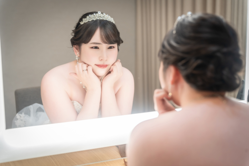 鏡に向かい表情を整える途中