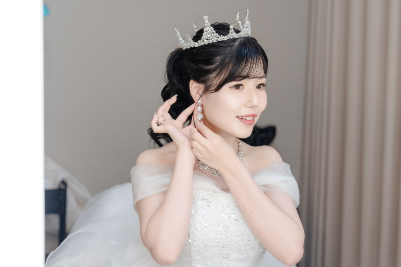 耳元に手を添えて整える身支度の集中