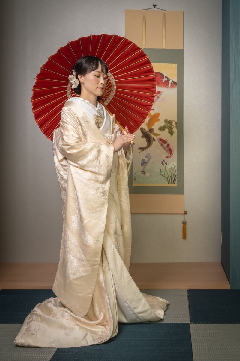 赤い番傘が白無垢を引き立てる華やかさ