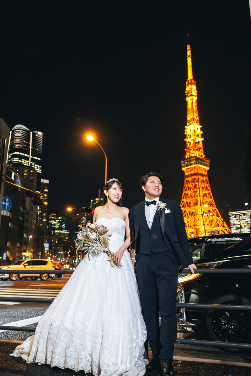 タワーを背に夜の交差点に立つ二人