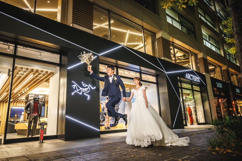 ジャンプしてブーケを掲げる男性と花嫁