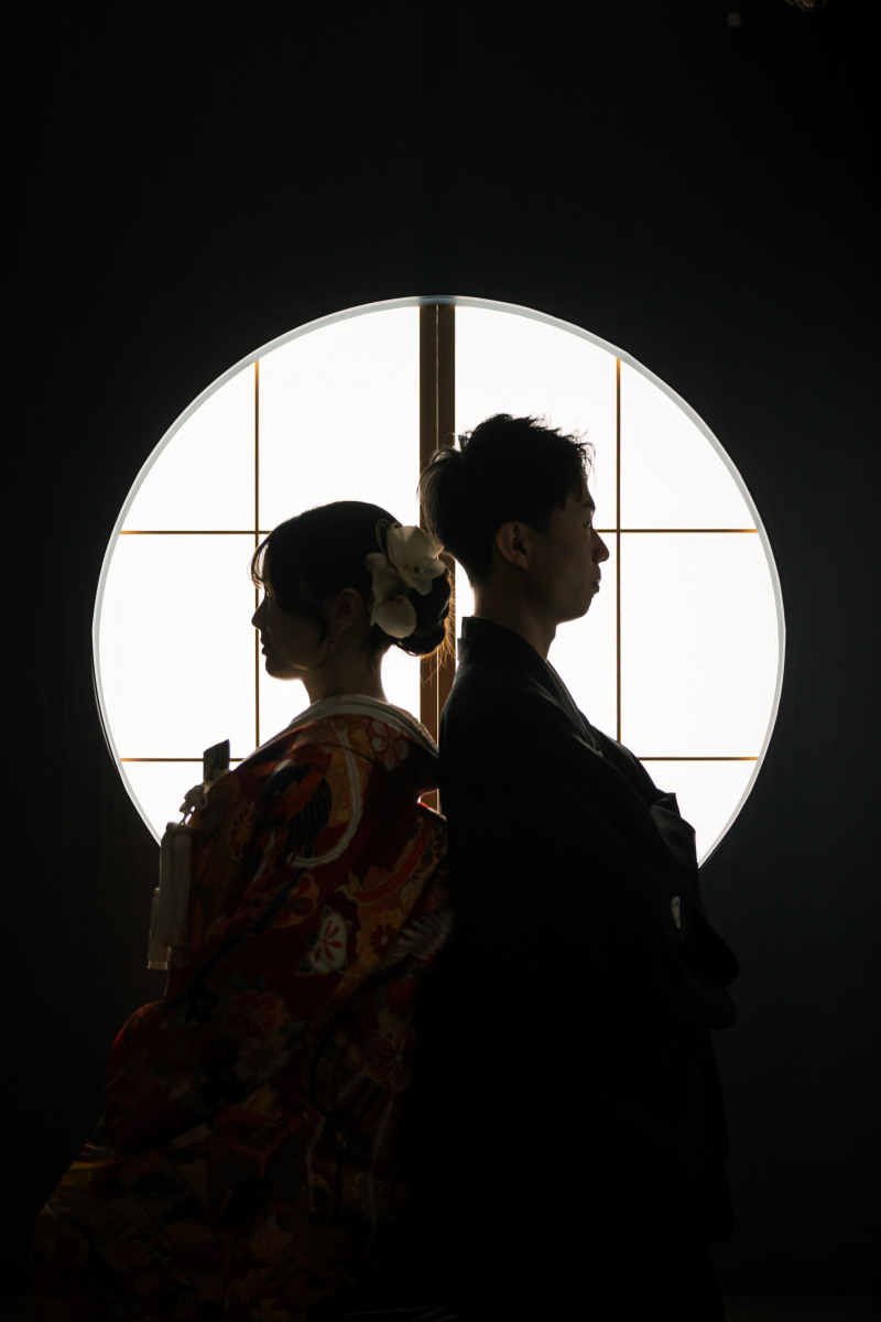 逆光の丸窓に浮かぶ和装シルエットの横顔