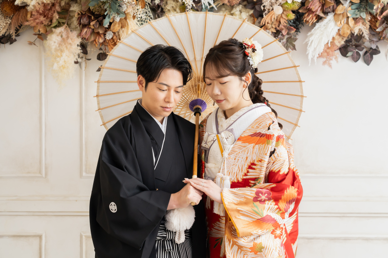 和装姿で手元を見つめ並ぶ新郎新婦様