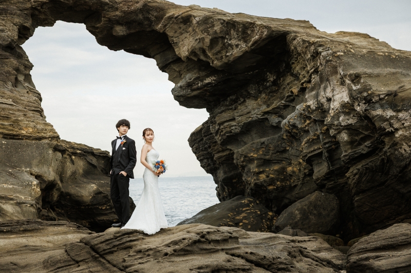 岩のアーチに佇む二人の表情