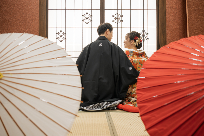 白と赤の番傘越しに映る正座の和装