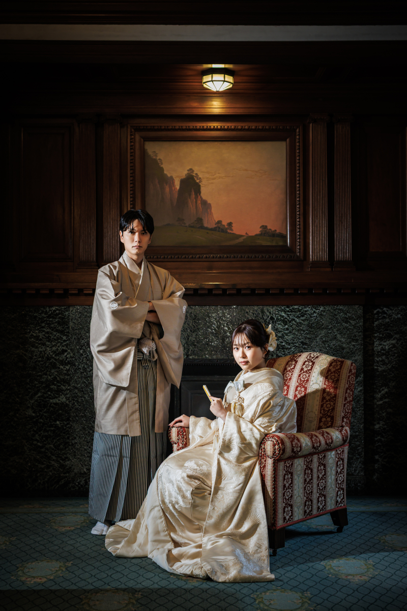 室内で新婦が着座し新郎が立位