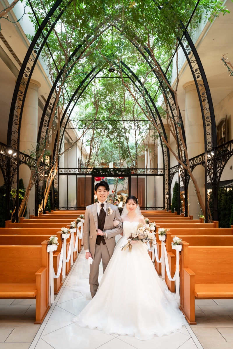 チャペルの長い通路を腕を組んで歩くふたり