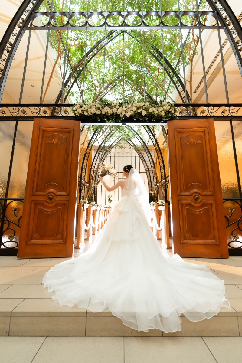 大扉の前に広がる白いトレーンの花嫁