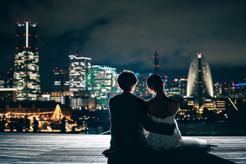 夜景を並んで眺める肩を寄せ合うふたりの後ろ姿