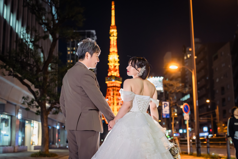東京タワーを背にした振り返り手繋ぎ