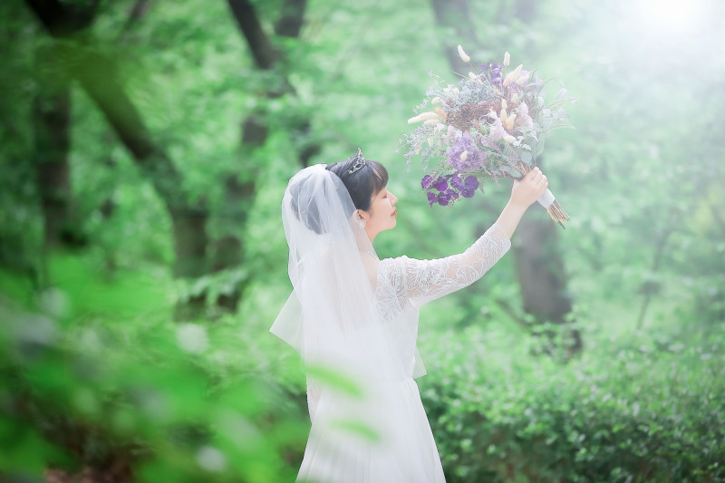 緑に包まれたスポットでブーケを掲げるソロショット