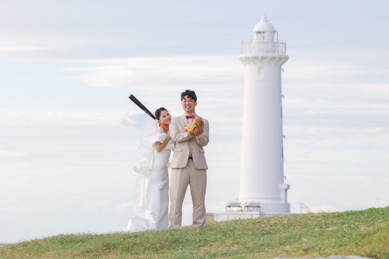 野間灯台を背景に、思い出のグローブとバットと共に