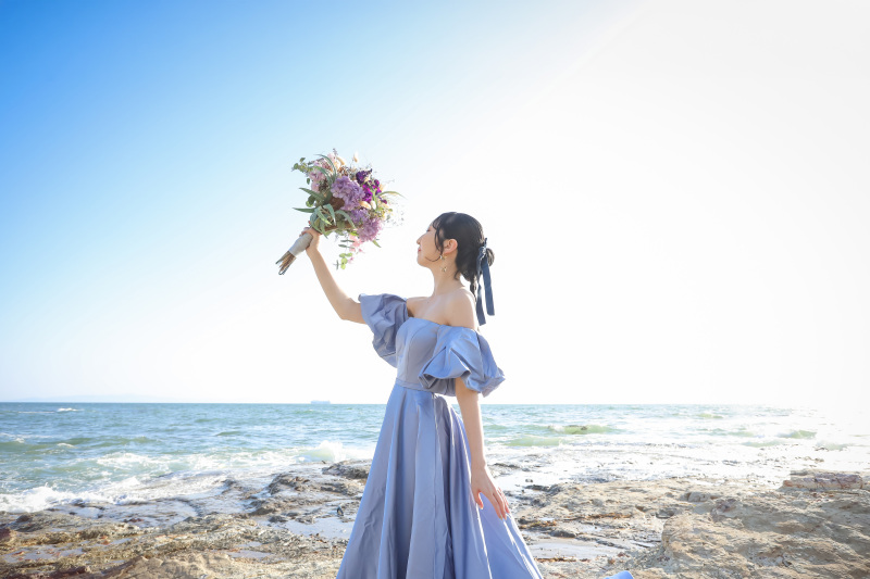 野間灯台の海辺でブーケを掲げる洋装花嫁ソロの一枚