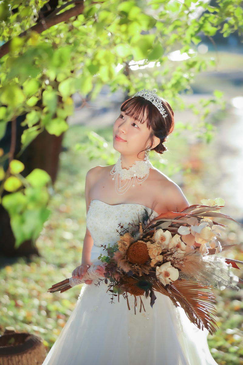 陽だまりに立つ花嫁様とブーケが彩る洋装のソロ写真