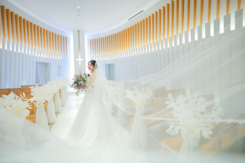 チャペルの祭壇前でベールが広がる花嫁様の洋装写真