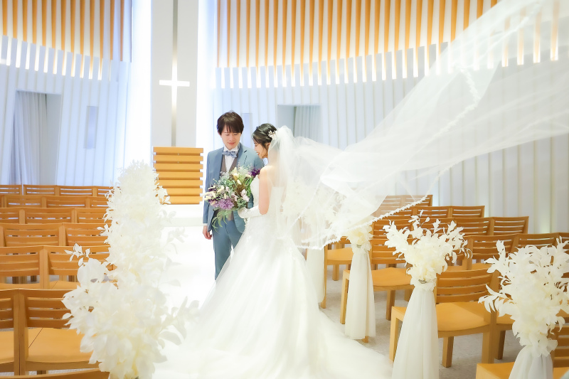 チャペルのバージンロードで向き合う洋装のおふたり