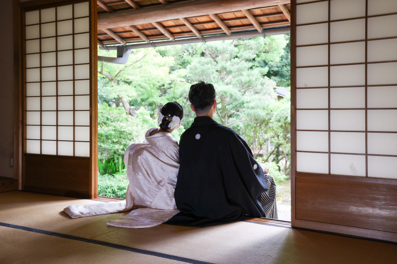 縁側に座り、庭園を眺めるおふたりの後ろ姿ショット