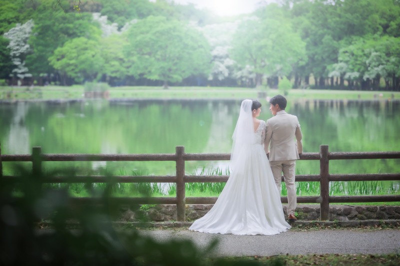 静かな池の畔で並ぶ二人の後ろ姿ウェディングカット