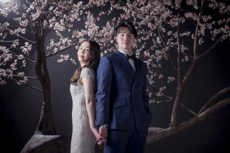 桜を背景に手繋ぎショットで仲睦まじいおふたり♪