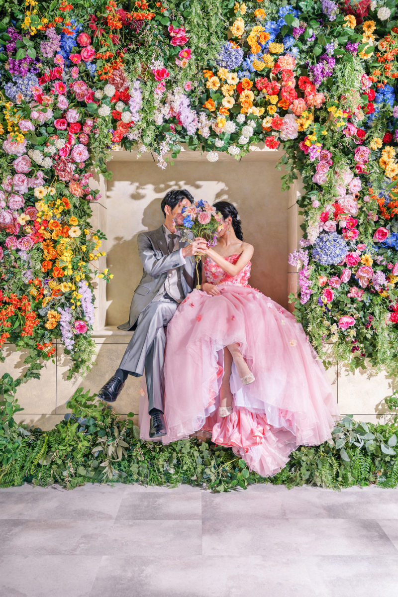 フラワーウォールに包まれて、そっと顔を隠して