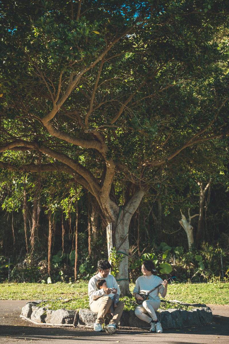 木陰で三線（さんしん）を弾いて唄う新婦様