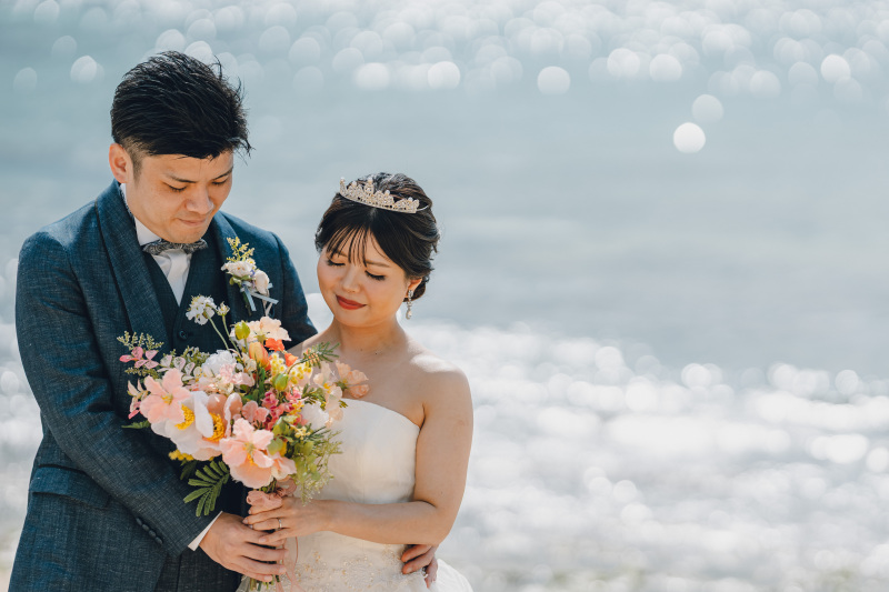 キラキラ光る海をバックに微笑むおふたり♡