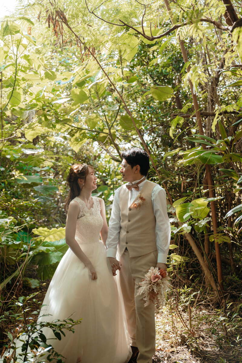 緑の小道をそっと手をつないで歩くふたり