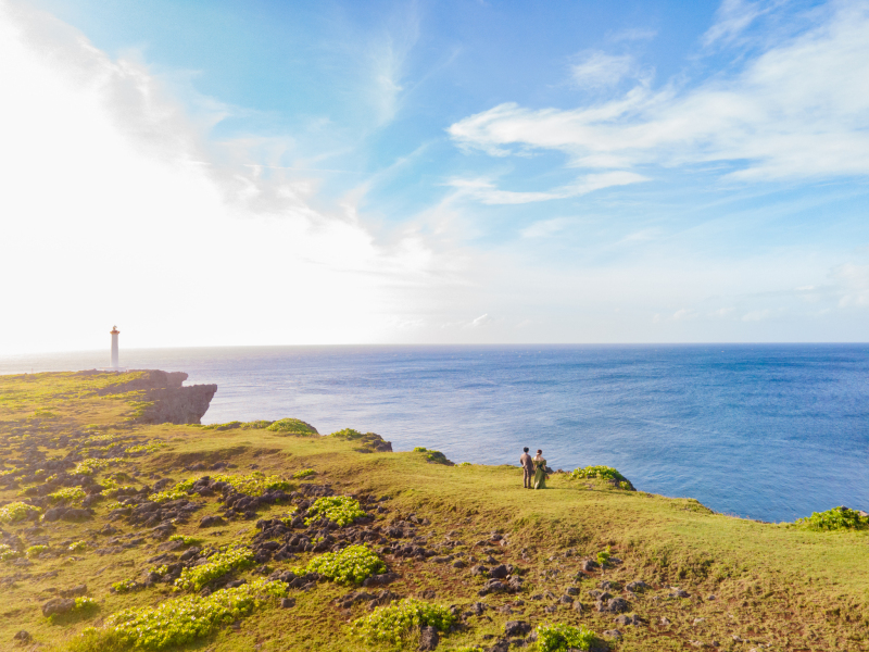 広がる海と空、そして壮大な断崖に立つふたり